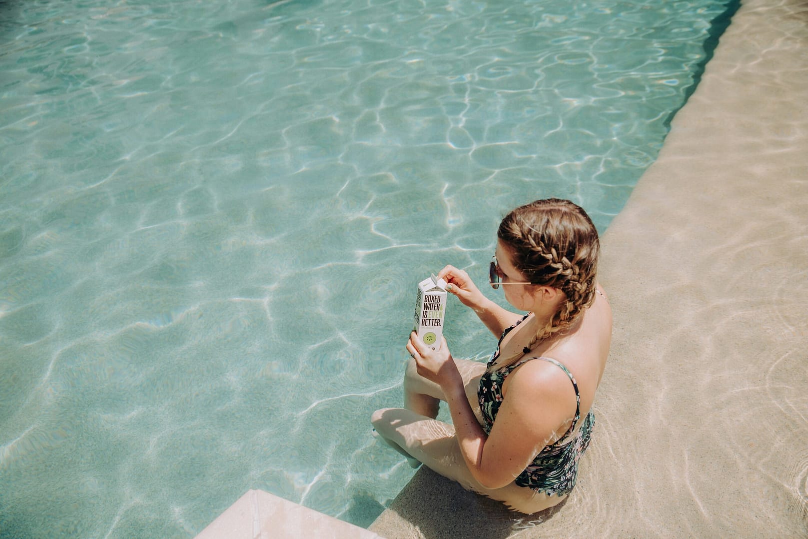 a woman sitting on the edge of a swimming pool
