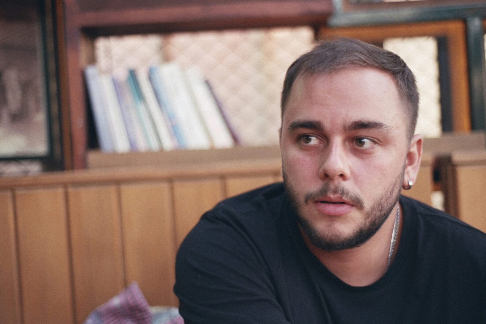 a man sitting in front of a book shelf