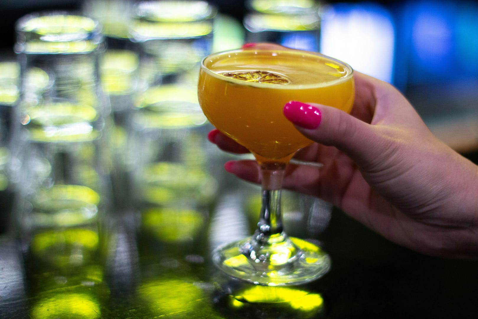 a woman holding a glass of orange juice