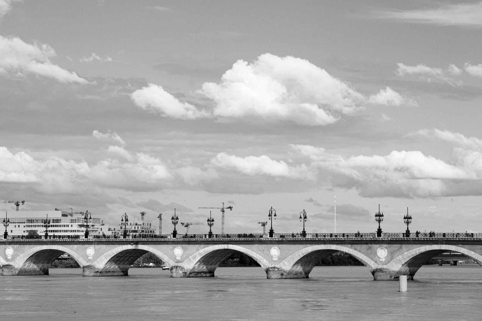 a black and white photo of a bridge over water
