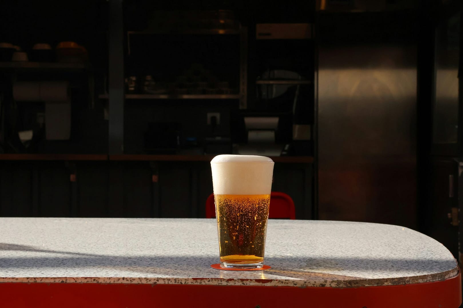 A glass of beer sitting on top of a table
