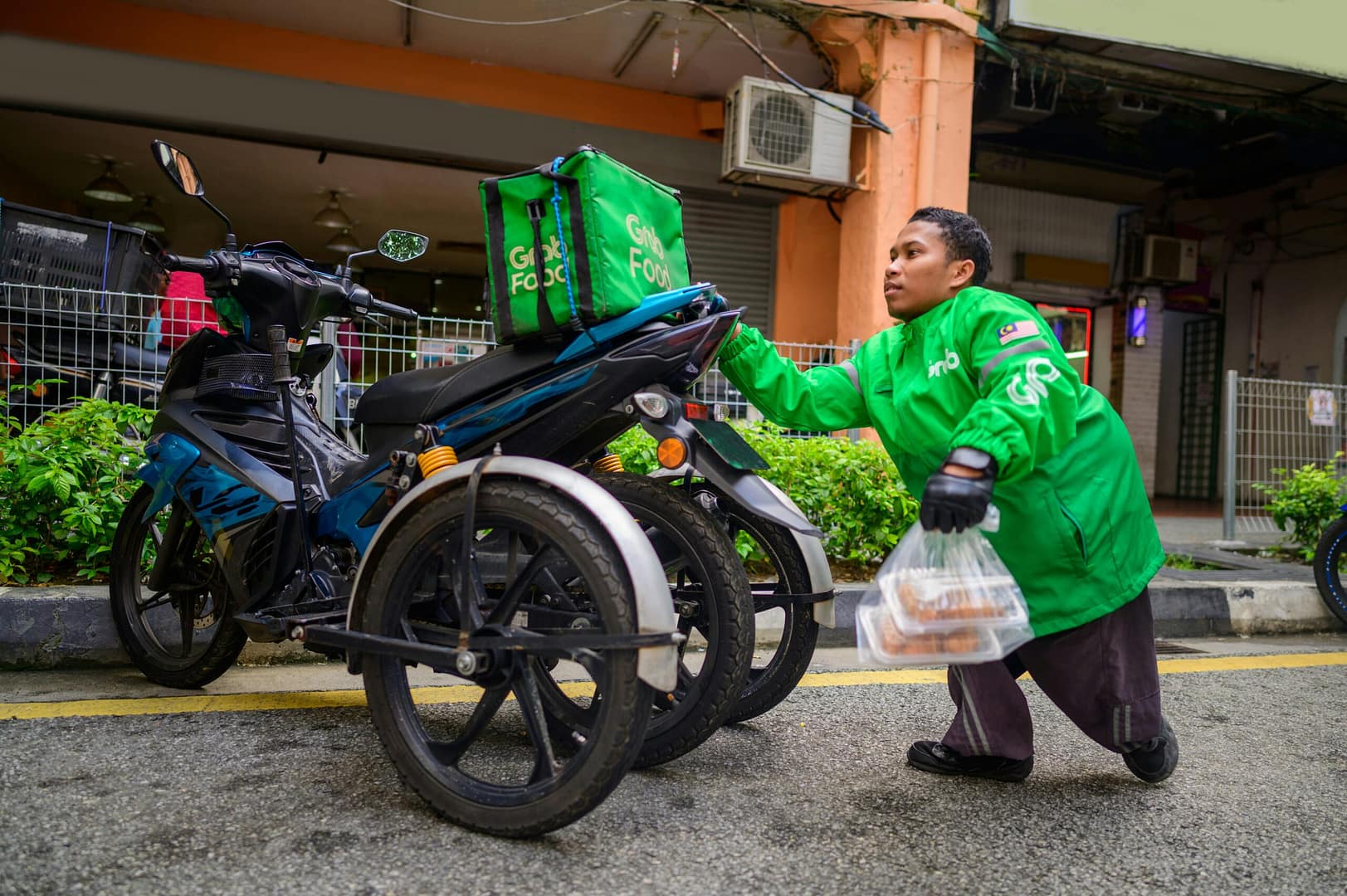 a man in a green jacket is next to a motorcycle